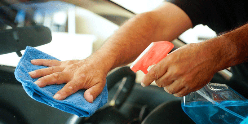 man cleaning windshield