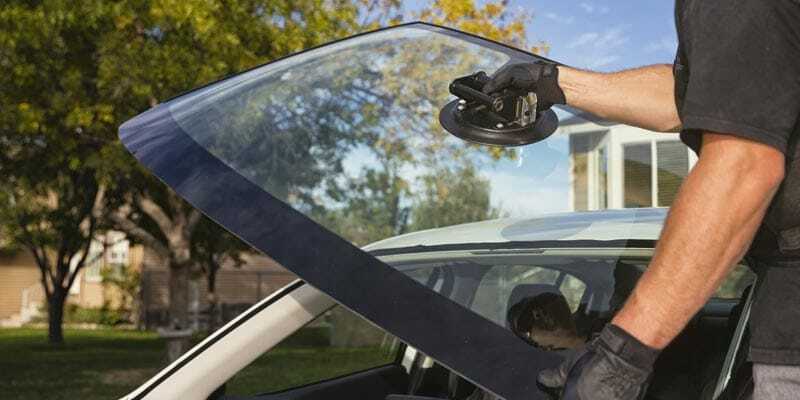 man replacing windshield